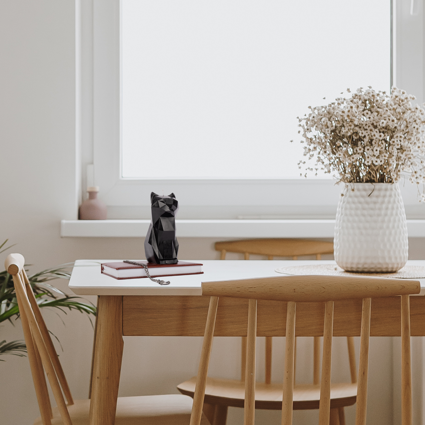 Gothic black cat candle on a wide windowsill table – aesthetic Halloween decor