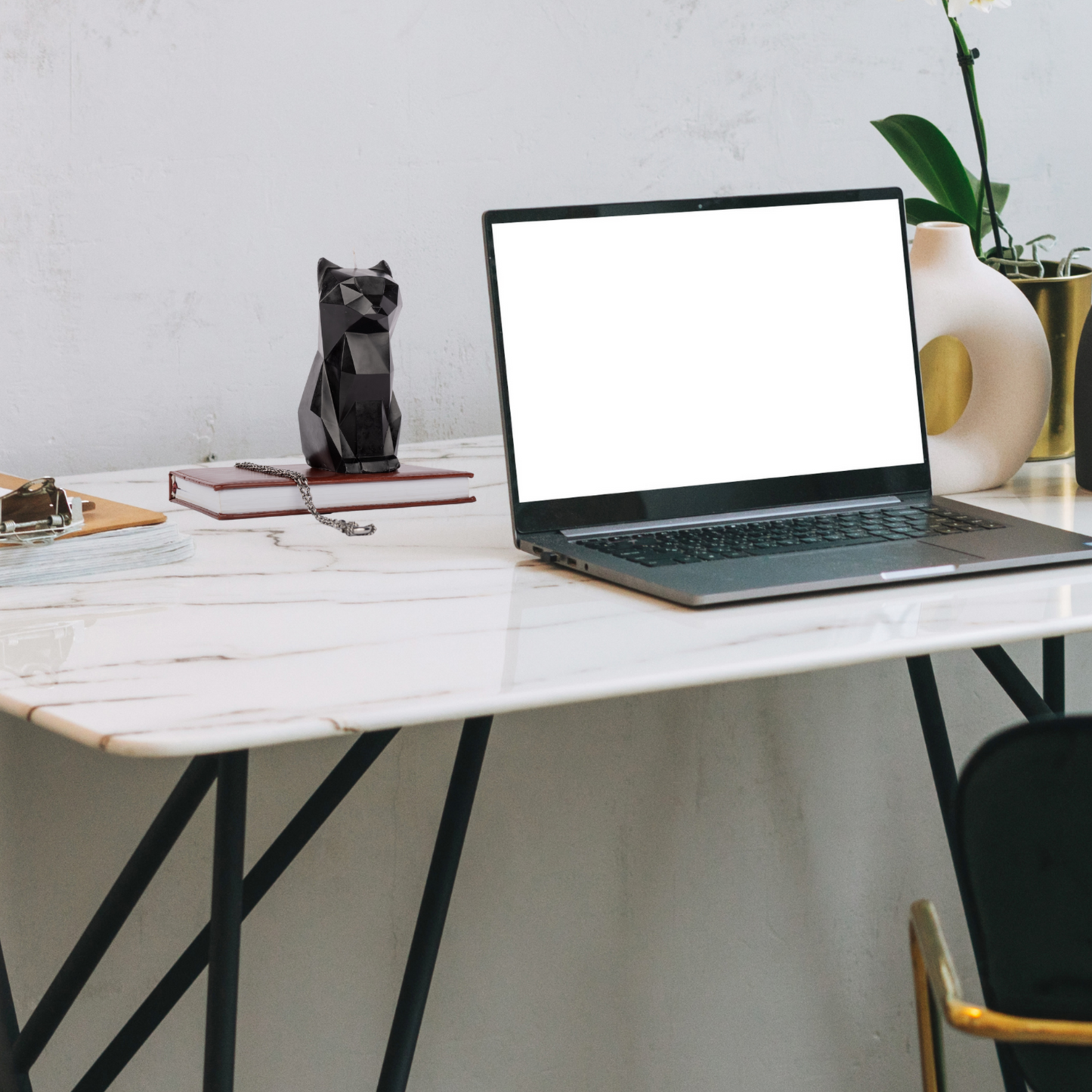 Black cat candle next to a laptop – gothic decor meets modern workspace vibes