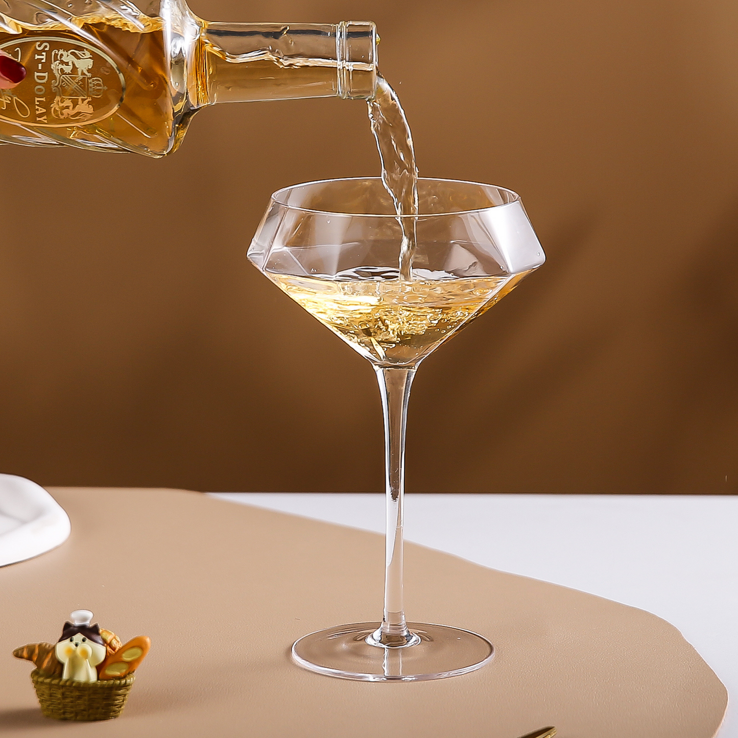 Pouring cocktail into martini glass from bottle