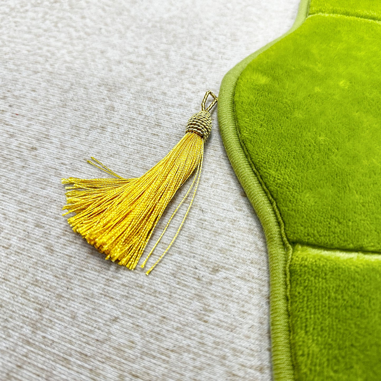Golden tassel on top of green Muslim prayer rug – elegant detail for Ramadan gifts and prayer