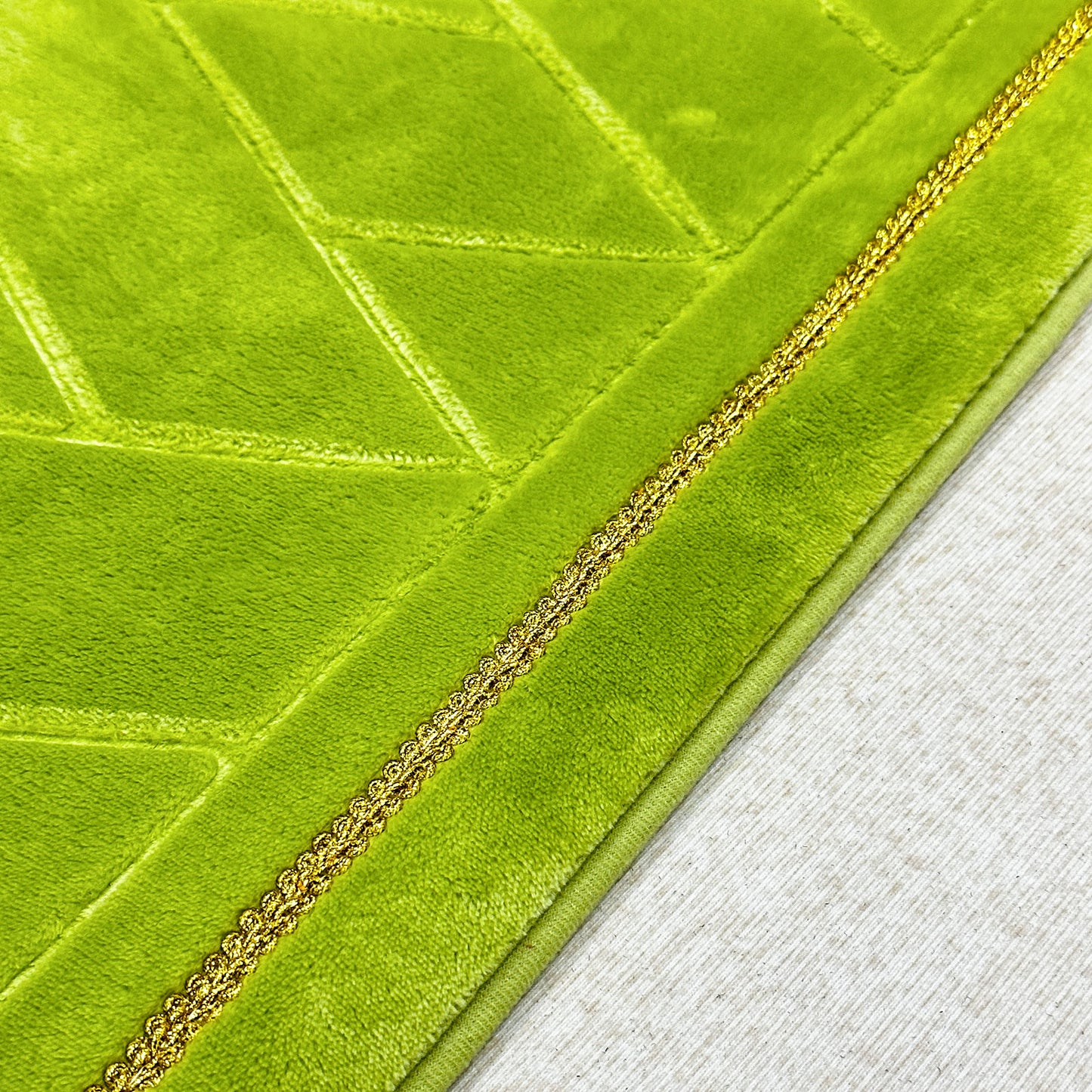 Gold-stitched edge detail on green Muslim prayer mat – premium islamic prayer rug finish