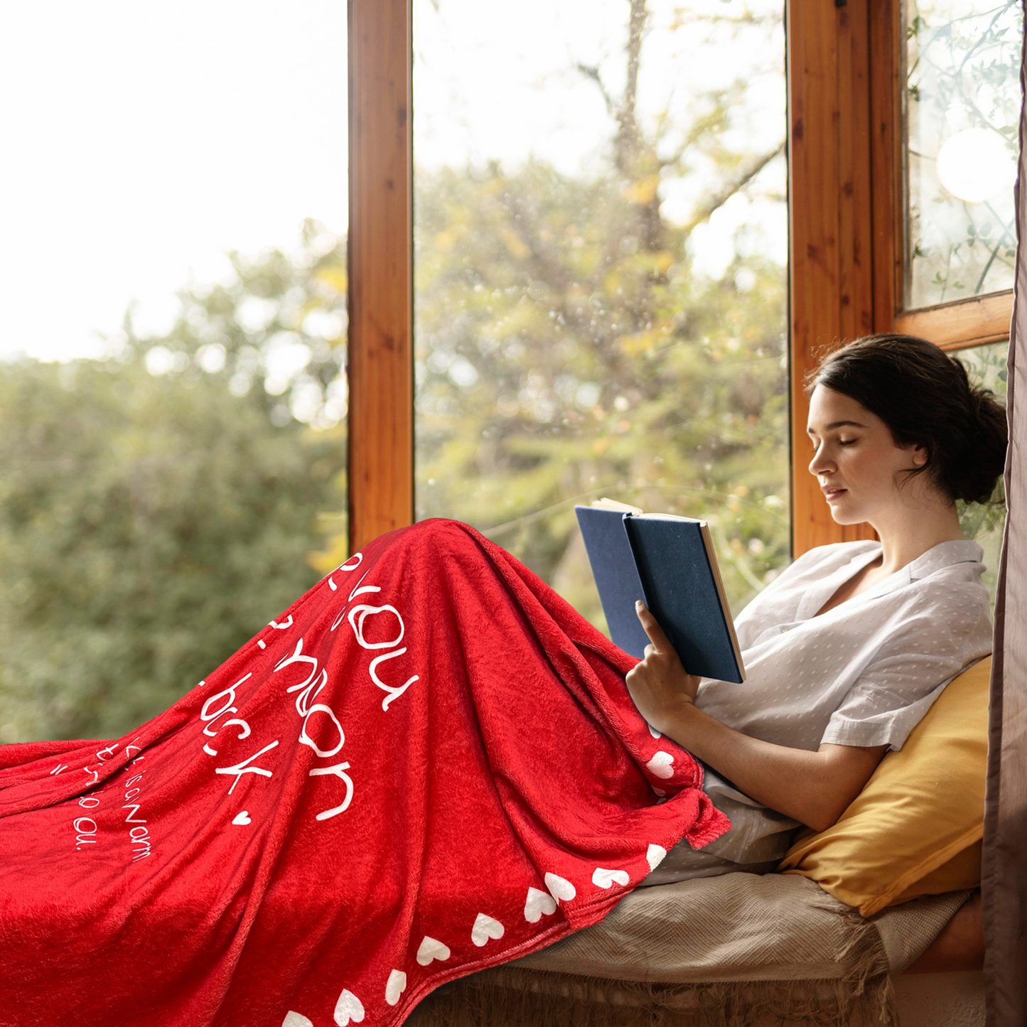 young woman is covered with a cozy red blanket