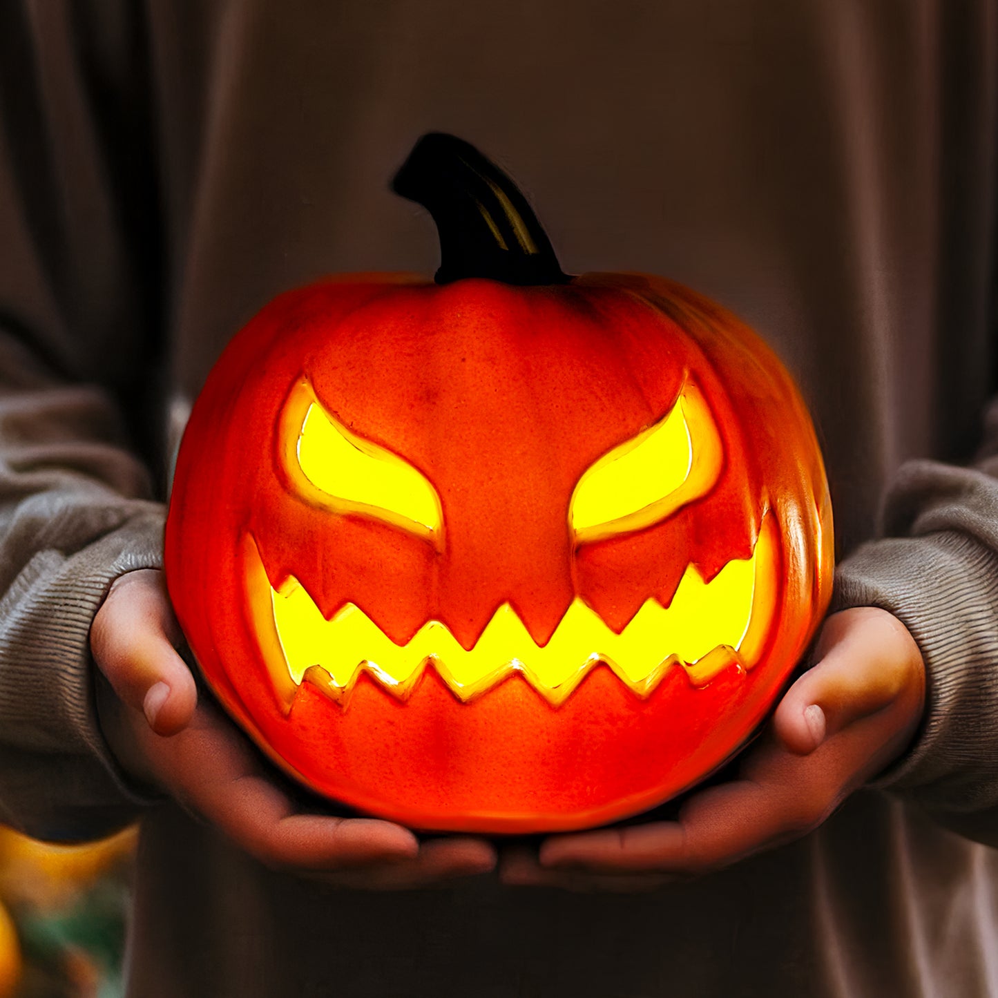 Glowing jack o lantern pumpkin held in hands – cozy Halloween home decor