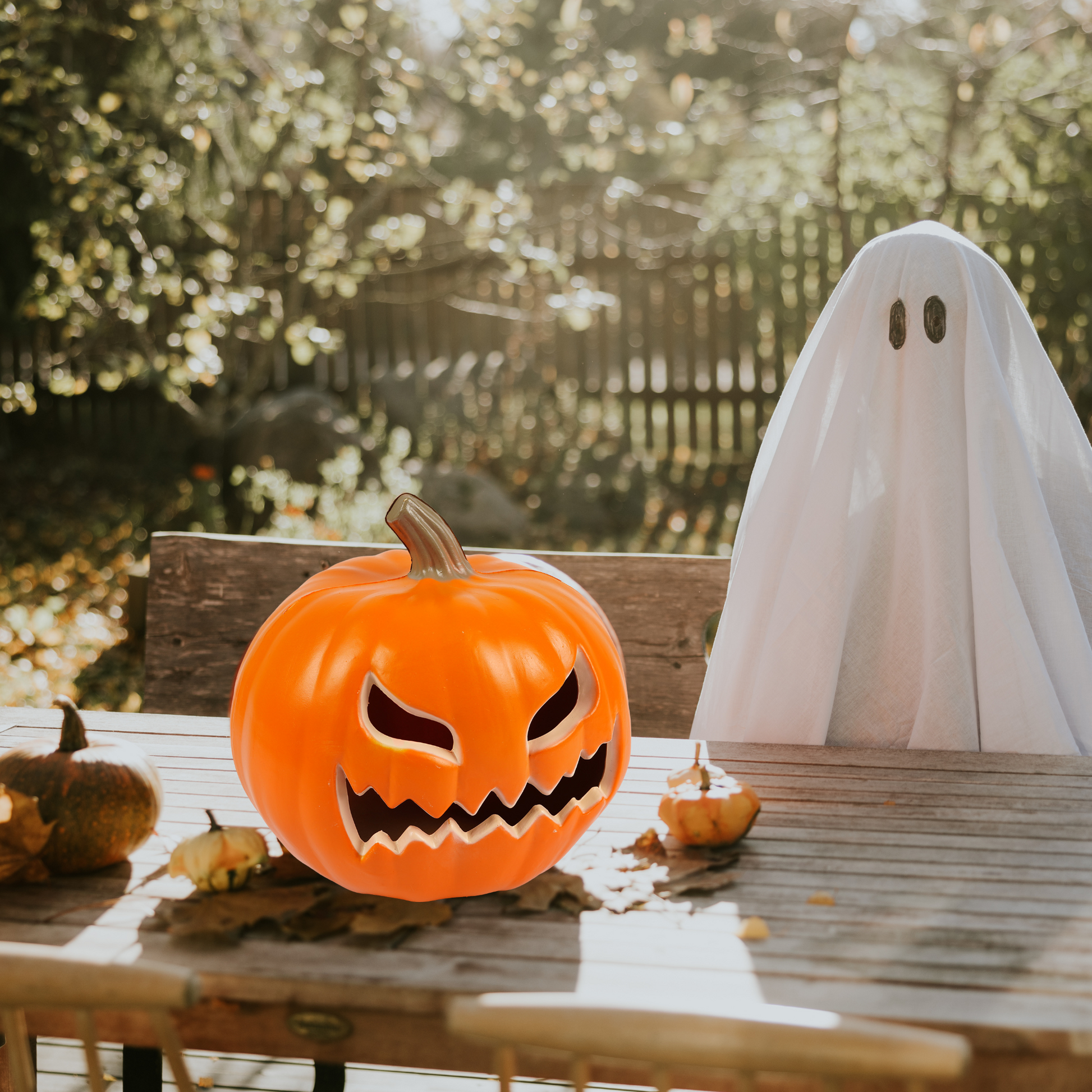 Outdoor Halloween table setup with spooky pumpkin and ghost decoration
