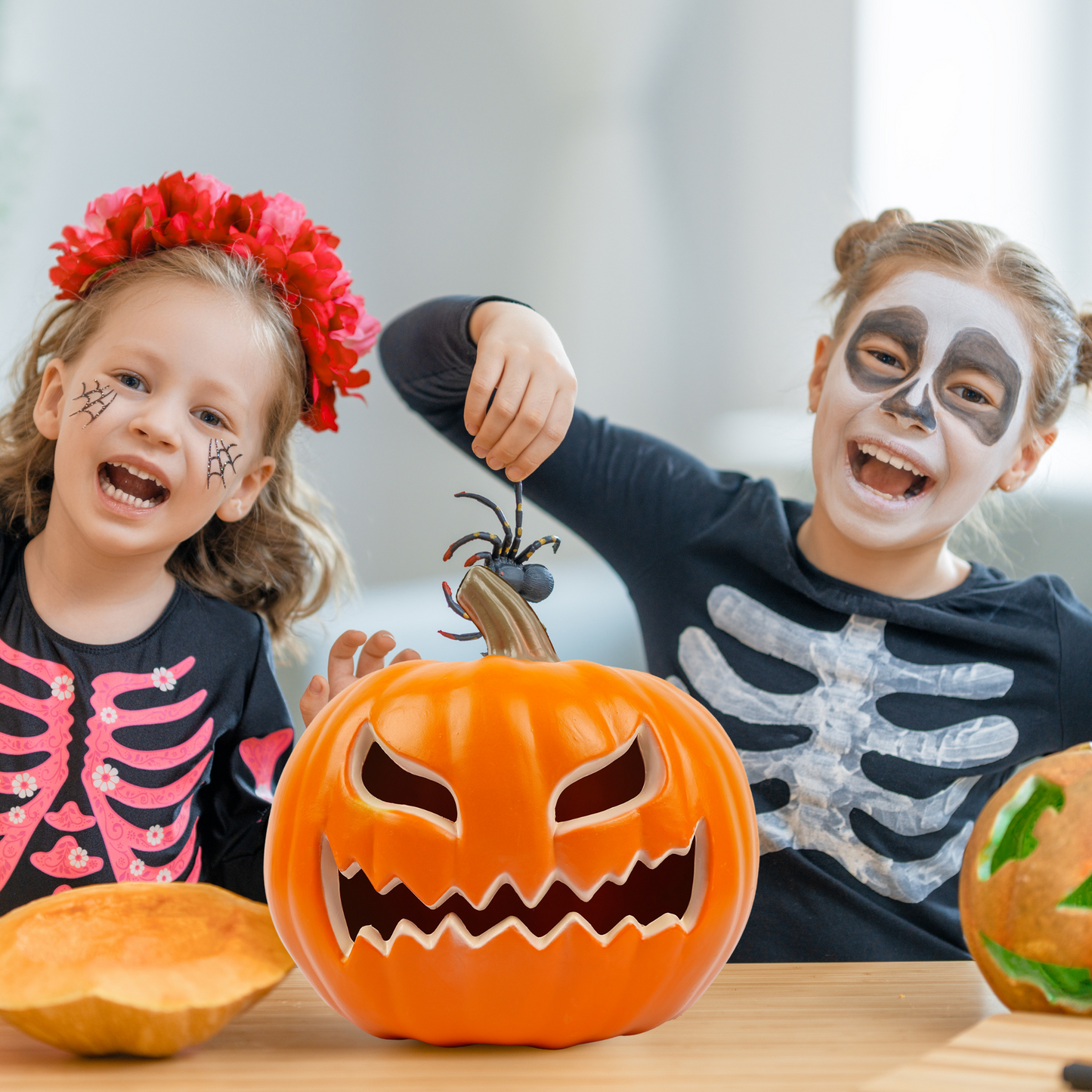 Kids in Halloween costumes with light-up pumpkin – party decorations scene