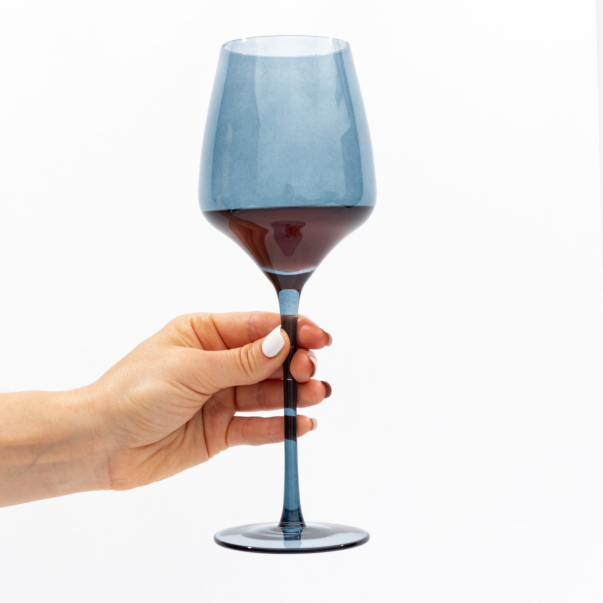 Elegant and modern blue wine glass with red wine in hand