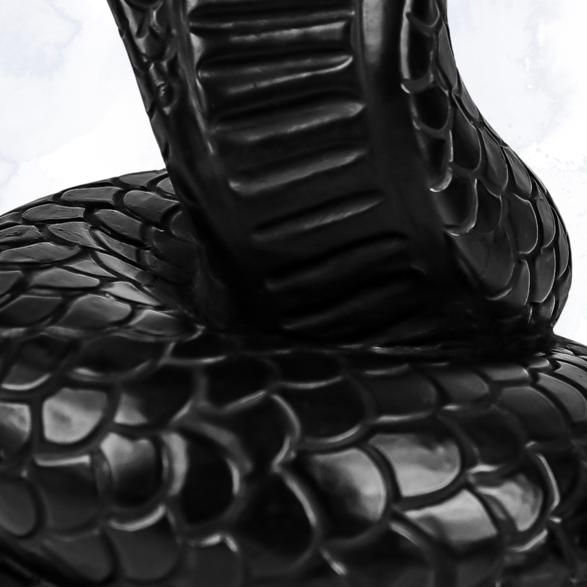 Close-up of cobra head and raised hood – black snake candle, skull decor, weird candles